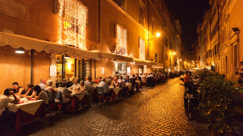 Delicosas mesas externas durante o jantar em Roma