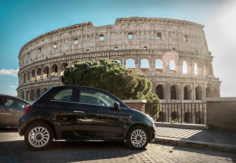 Carro parado em frente ao Coliseu de Roma na Itália