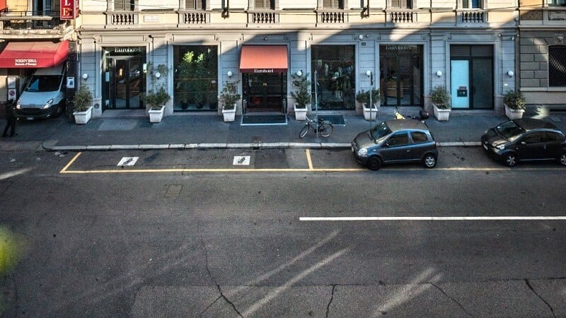 Carros estacionados em rua de Milão