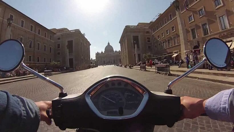 Pessoa conduzindo uma moto no Vaticano em Roma