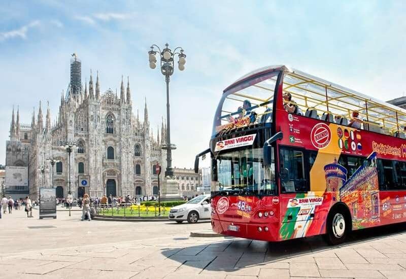 Ônibus turístico passando pela Catedral de Milão