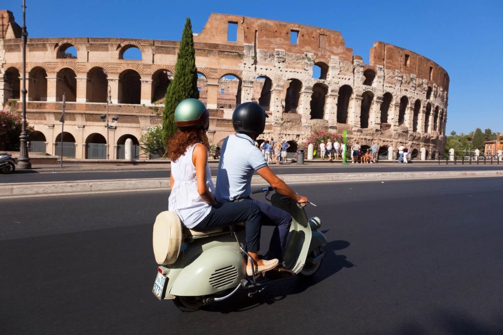 Pessoas andando de vespa em Roma