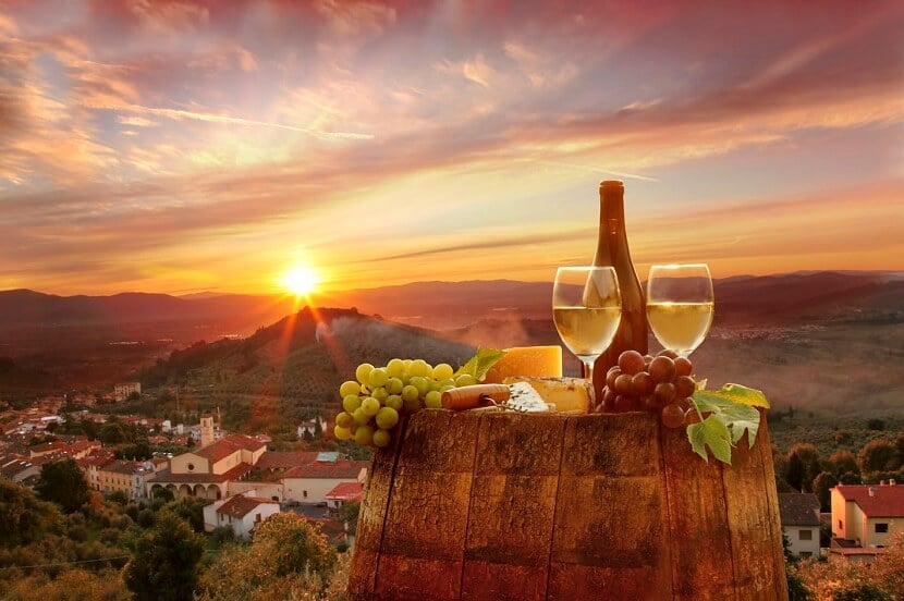 Taças de vinhos, queijos e frutas com linda paisagem ao fundo