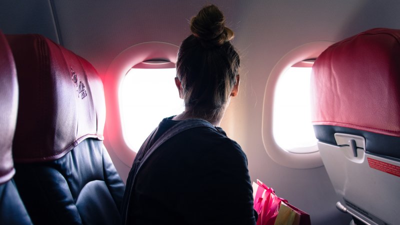 Mulher olhando na janela do avião